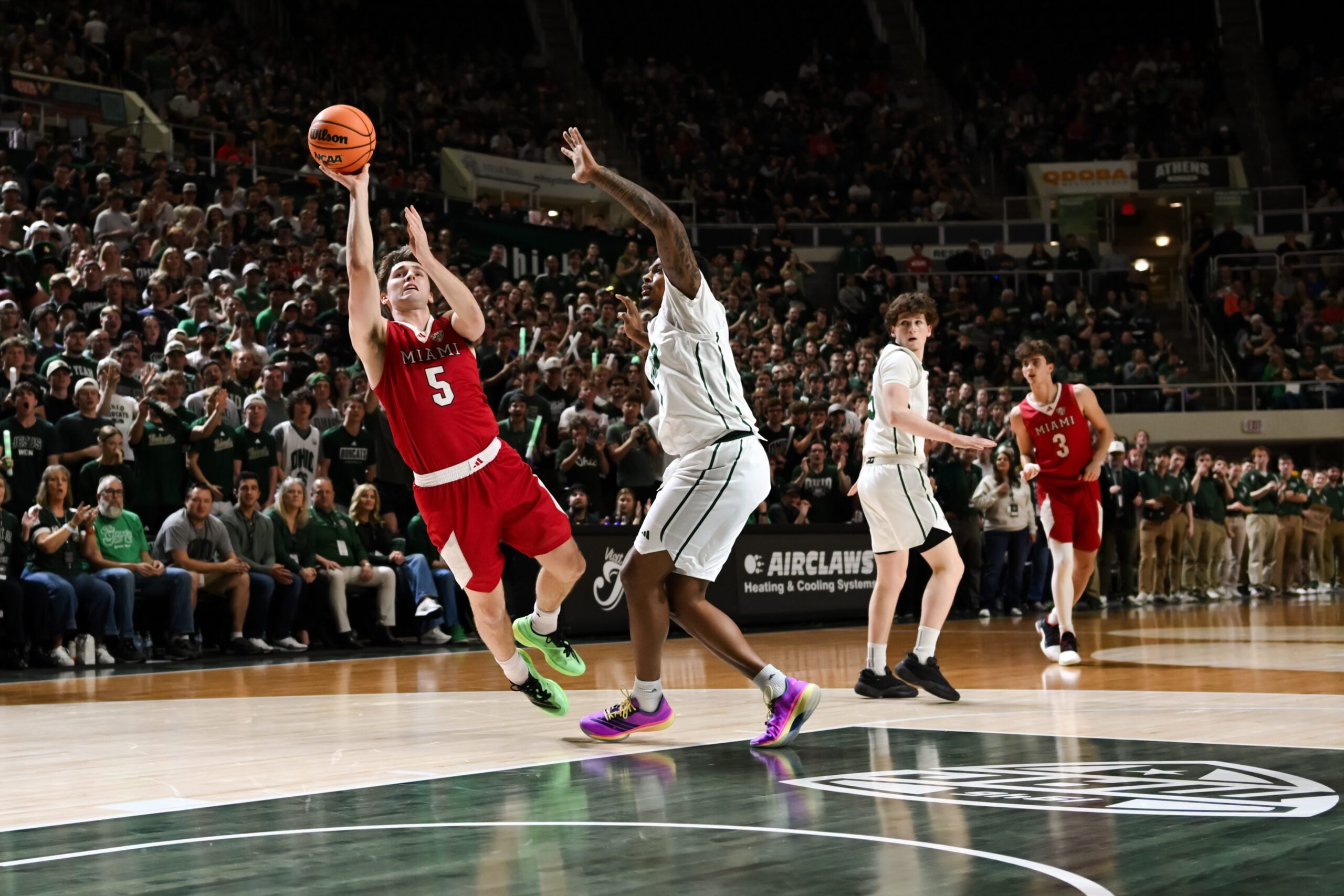 Mar 6, 2026; Athens, Ohio, USA;  Miami (OH) RedHawks guard Peter Suder (5) drives to the basket as he is fouled by Ohio Bobcats forward Javan Simmons (1) in the second half at the Convocation Center. Mandatory Credit: Aaron Doster-Imagn Images