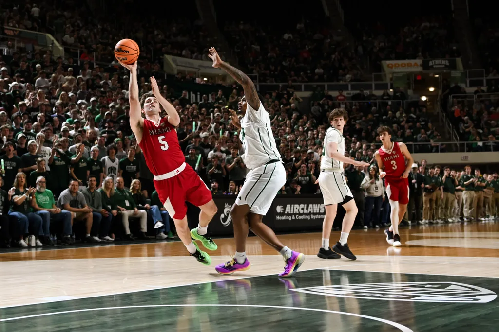 Mar 6, 2026; Athens, Ohio, USA; Miami (OH) RedHawks guard Peter Suder (5) drives to the basket as he is fouled by Ohio Bobcats forward Javan Simmons (1) in the second half at the Convocation Center. Mandatory Credit: Aaron Doster-Imagn Images