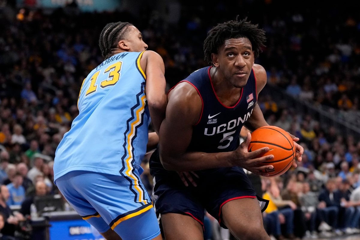 Mar 7, 2026; Milwaukee, Wisconsin, USA; Connecticut Huskies center Tarris Reed Jr. (5) looks to shoot against Marquette Golden Eagles forward Royce Parham (13) during the first half at Fiserv Forum. Mandatory Credit: Jeff Hanisch-Imagn Images