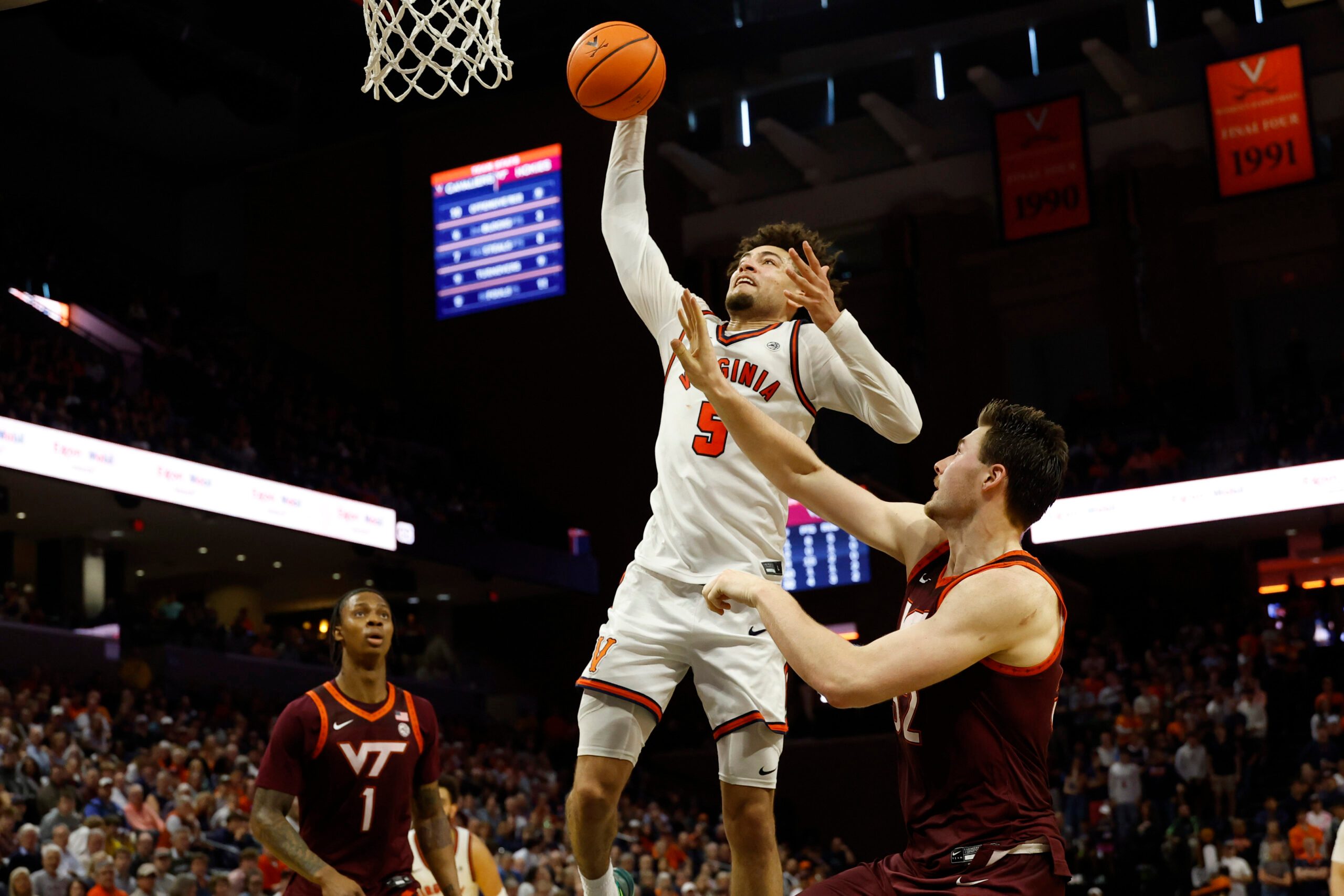 Mar 7, 2026; Charlottesville, Virginia, USA; Virginia Cavaliers guard Sam Lewis (5) attempts a dunks as Virginia Tech Hokies center Christian Gurdak (32) defends in the second half at John Paul Jones Arena. Mandatory Credit: Geoff Burke-Imagn Images