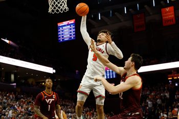 Mar 7, 2026; Charlottesville, Virginia, USA; Virginia Cavaliers guard Sam Lewis (5) attempts a dunks as Virginia Tech Hokies center Christian Gurdak (32) defends in the second half at John Paul Jones Arena. Mandatory Credit: Geoff Burke-Imagn Images