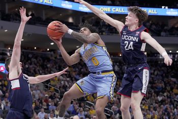 Marquette guard Nigel James Jr. (0) tries to score on UConn guard Braylon Mullins (24) during the first half of their game Saturday, March 7, 2026 at Fiserv Forum in Milwaukee, Wisconsin.