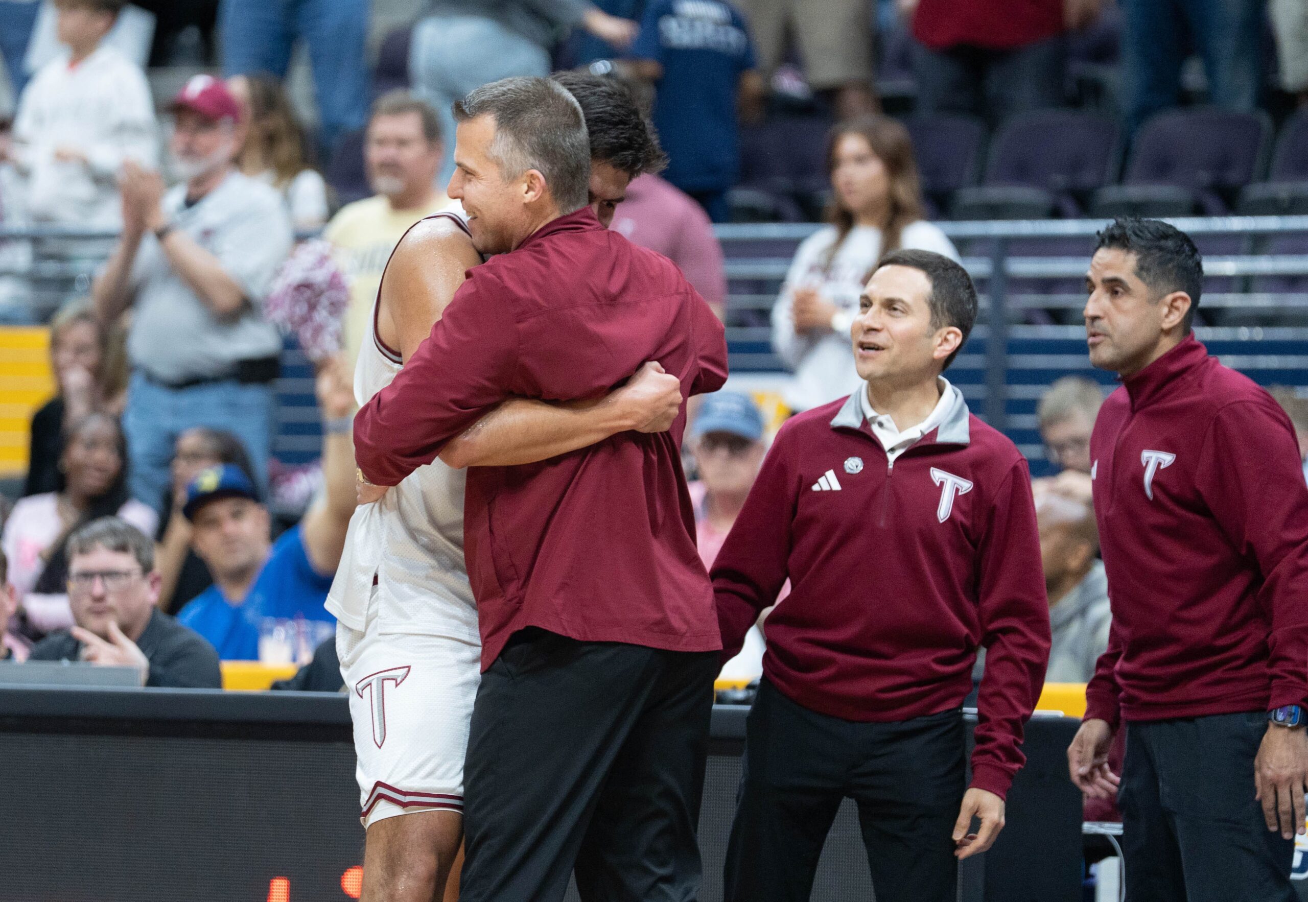 Trojans Victor Valdes (11) and head coach Scott Cross embrace as time runs down in their 77-61 victory over the Eagles during the Georgia Southern vs Troy men’s Sun Belt Conference Championship basketball game at the Pensacola Bay Center in Pensacola, Florida on March 9, 2026.
