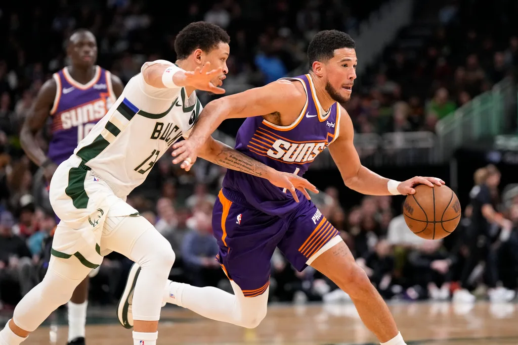 Mar 10, 2026; Milwaukee, Wisconsin, USA; Phoenix Suns guard Devin Booker (1) drives towards the basket against Milwaukee Bucks guard Ryan Rollins (13) during the third quarter at Fiserv Forum. Mandatory Credit: Jeff Hanisch-Imagn Images