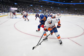 Mar 10, 2026; St. Louis, Missouri, USA; New York Islanders center Mathew Barzal (13) and St. Louis Blues defenseman Colton Parayko (55) battle for the puck during the third period at Enterprise Center. Mandatory Credit: Jeff Curry-Imagn Images