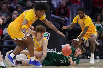 Ohio Bobcats guard Jesse Burris (21) tries to get rid of the ball under pressure from Kent State Golden Flashes guard Rob Whaley Jr. (2), forward Magnus Entenmann (14) and guard Cian Medley (1) during the second half of an NCAA college basketball game in the quarterfinals of the MAC Basketball Tournament at Rocket Arena, March 12, 2026, in Cleveland, Ohio.
