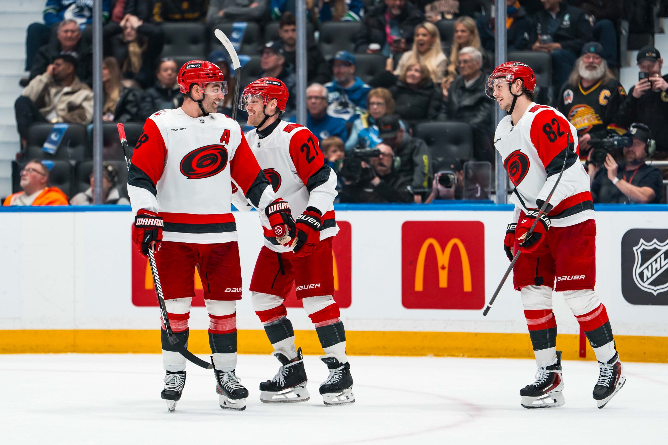 Mar 4, 2026; Vancouver, British Columbia, CAN; Carolina Hurricanes forward Jordan Martinook (48) and forward Nikolaj Ehlers (27) and forward Jesperi Kotkaniemi (82) celebrate Ehler’s second goal of the game against the Vancouver Canucks in the second period at Rogers Arena. Mandatory Credit: Bob Frid-Imagn Images