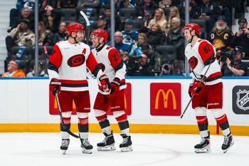 Mar 4, 2026; Vancouver, British Columbia, CAN; Carolina Hurricanes forward Jordan Martinook (48) and forward Nikolaj Ehlers (27) and forward Jesperi Kotkaniemi (82) celebrate Ehler’s second goal of the game against the Vancouver Canucks in the second period at Rogers Arena. Mandatory Credit: Bob Frid-Imagn Images