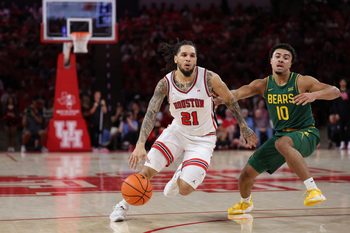 Mar 4, 2026; Houston, Texas, USA;  Houston Cougars guard Emanuel Sharp (21) dribbles against Baylor Bears guard Isaac Williams (10) in the first half at Fertitta Center. Mandatory Credit: Thomas Shea-Imagn Images