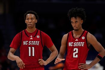 Mar 12, 2026; Charlotte, NC, USA; NC State Wolfpack guard Quadir Copeland (11) and guard Jr. Paul McNeil (2) in the final seconds during the second half against the Virginia Cavaliers at Spectrum Center. Mandatory Credit: Jim Dedmon-Imagn Images