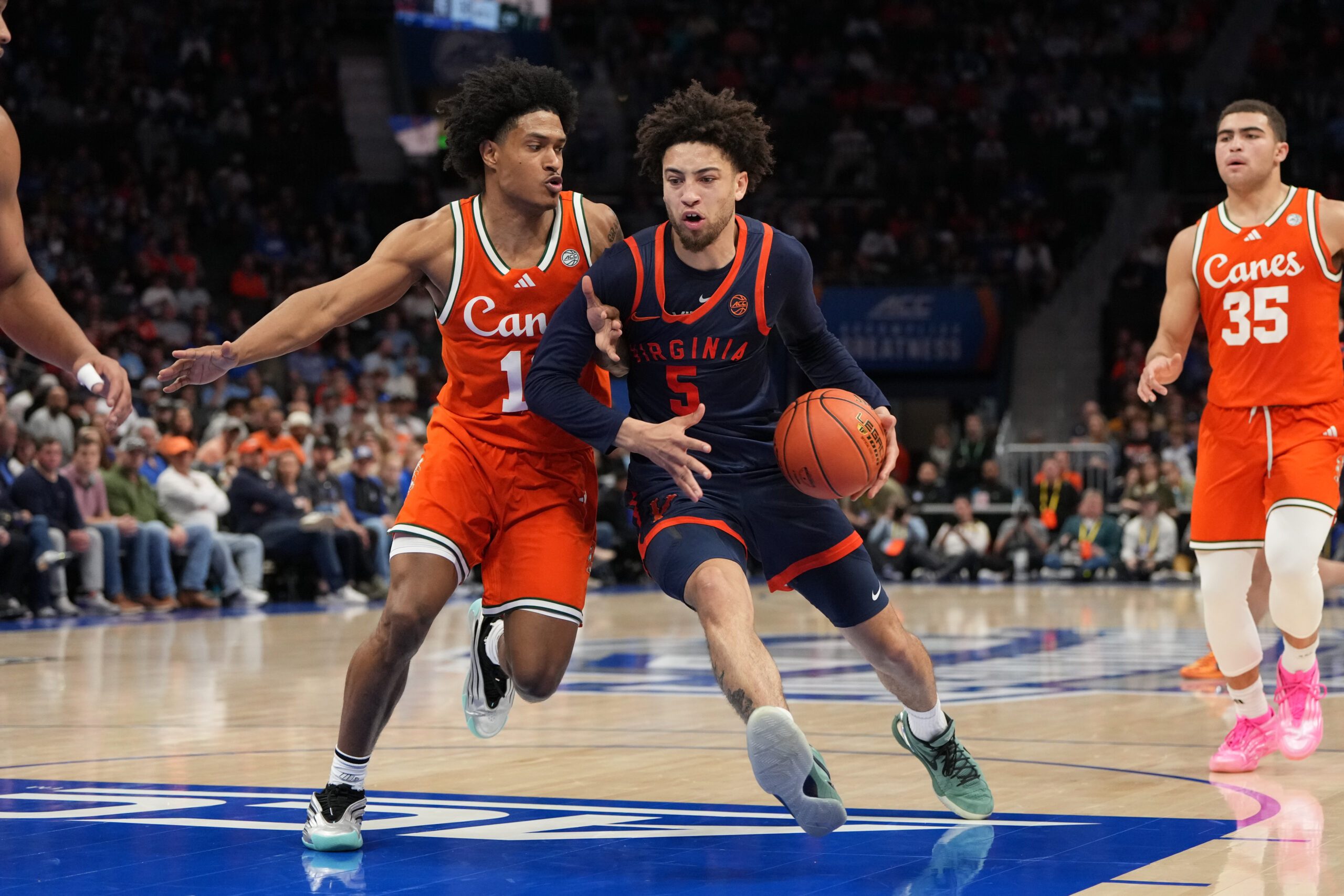 Mar 13, 2026; Charlotte, NC, USA; Virginia Cavaliers guard Sam Lewis (5) with the ball as Miami (FL) Hurricanes guard Tru Washington (10) defends in the second half at Spectrum Center. Mandatory Credit: Bob Donnan-Imagn Images