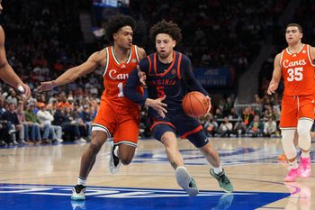 Mar 13, 2026; Charlotte, NC, USA; Virginia Cavaliers guard Sam Lewis (5) with the ball as Miami (FL) Hurricanes guard Tru Washington (10) defends in the second half at Spectrum Center. Mandatory Credit: Bob Donnan-Imagn Images