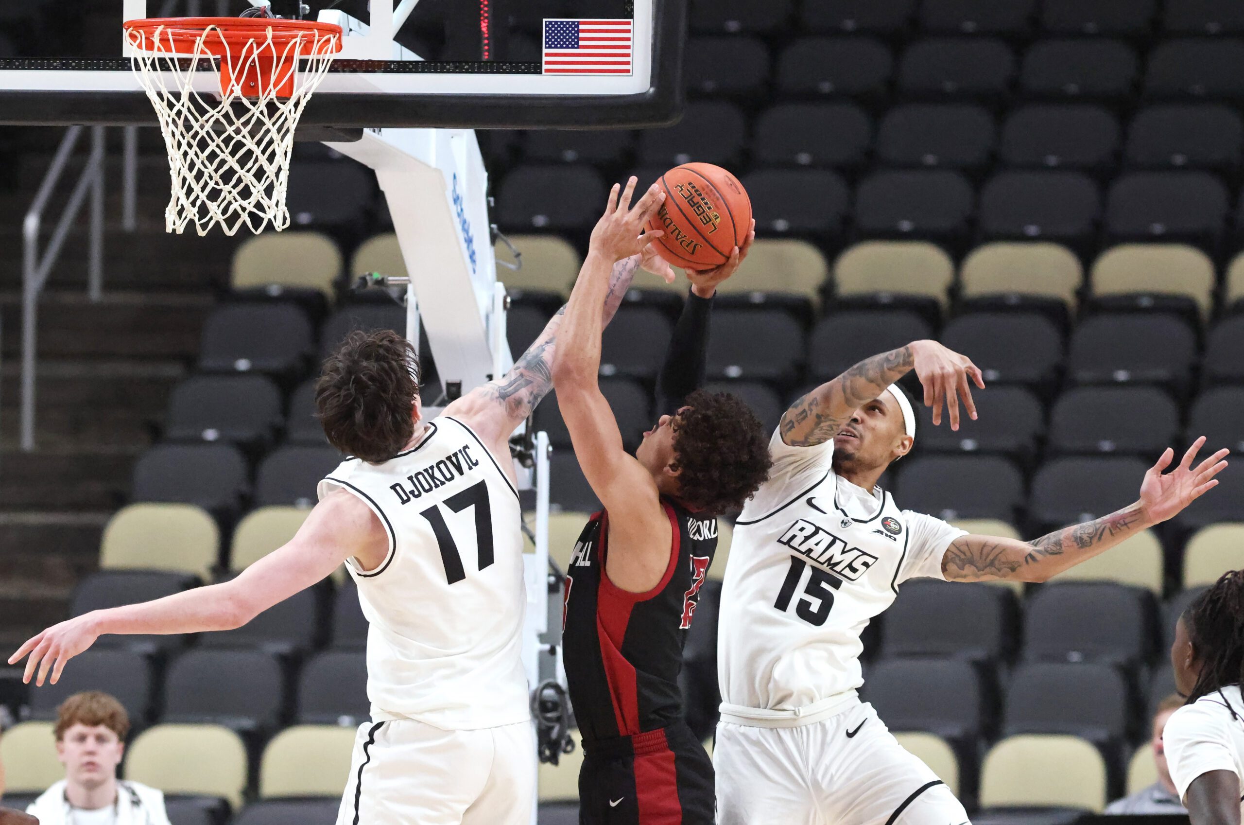 Mar 14, 2026; Pittsburgh, PA, USA;  VCU Rams forward Lazar Djokovic (17) and guard Tyrell Ward (15) defend Saint Joseph's Hawks guard Austin Willgford (13) during the second half in an Atlantic 10 Conference Tournament semifinal game at PPG Paints Arena. Mandatory Credit: Charles LeClaire-Imagn Images