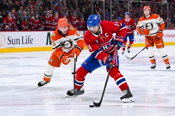 Mar 15, 2026; Montreal, Quebec, CAN; Montreal Canadiens center Nick Suzuki (14) plays the puck against Anaheim Ducks defenseman Jacob Trouba (65) during the third period at Bell Centre. Mandatory Credit: David Kirouac-Imagn Images