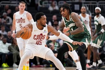 Mar 17, 2026; Milwaukee, Wisconsin, USA; Cleveland Cavaliers guard Donovan Mitchell (45) drives against Milwaukee Bucks guard/forward Kevin Porter Jr. (7) in the second half at Fiserv Forum. Mandatory Credit: Michael McLoone-Imagn Images