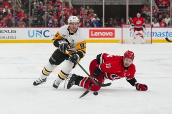 Mar 18, 2026; Raleigh, North Carolina, USA;  Carolina Hurricanes center Sebastian Aho (20) and Pittsburgh Penguins center Sidney Crosby (87) battle over the puck during the third period at Lenovo Center. Mandatory Credit: James Guillory-Imagn Images
