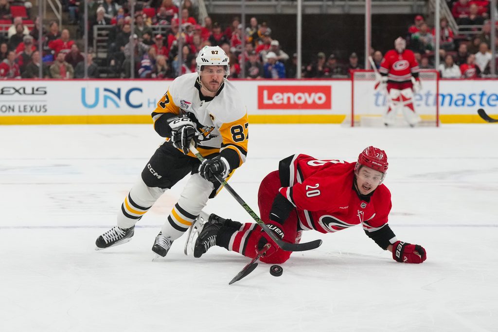 Mar 18, 2026; Raleigh, North Carolina, USA; Carolina Hurricanes center Sebastian Aho (20) and Pittsburgh Penguins center Sidney Crosby (87) battle over the puck during the third period at Lenovo Center. Mandatory Credit: James Guillory-Imagn Images