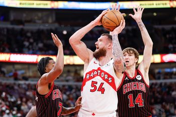 Mar 18, 2026; Chicago, Illinois, USA; Toronto Raptors forward Sandro Mamukelashvili (54) looks to pass the ball against Chicago Bulls guard Rob Dillingham (7) during the first half at United Center. Mandatory Credit: Kamil Krzaczynski-Imagn Images
