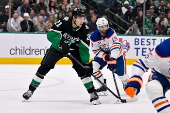 Mar 12, 2026; Dallas, Texas, USA; Dallas Stars left wing Jason Robertson (21) and Edmonton Oilers center Adam Henrique (19) look for the puck during the game between the Stars and the Oilers at the American Airlines Center. Mandatory Credit: Jerome Miron-Imagn Images