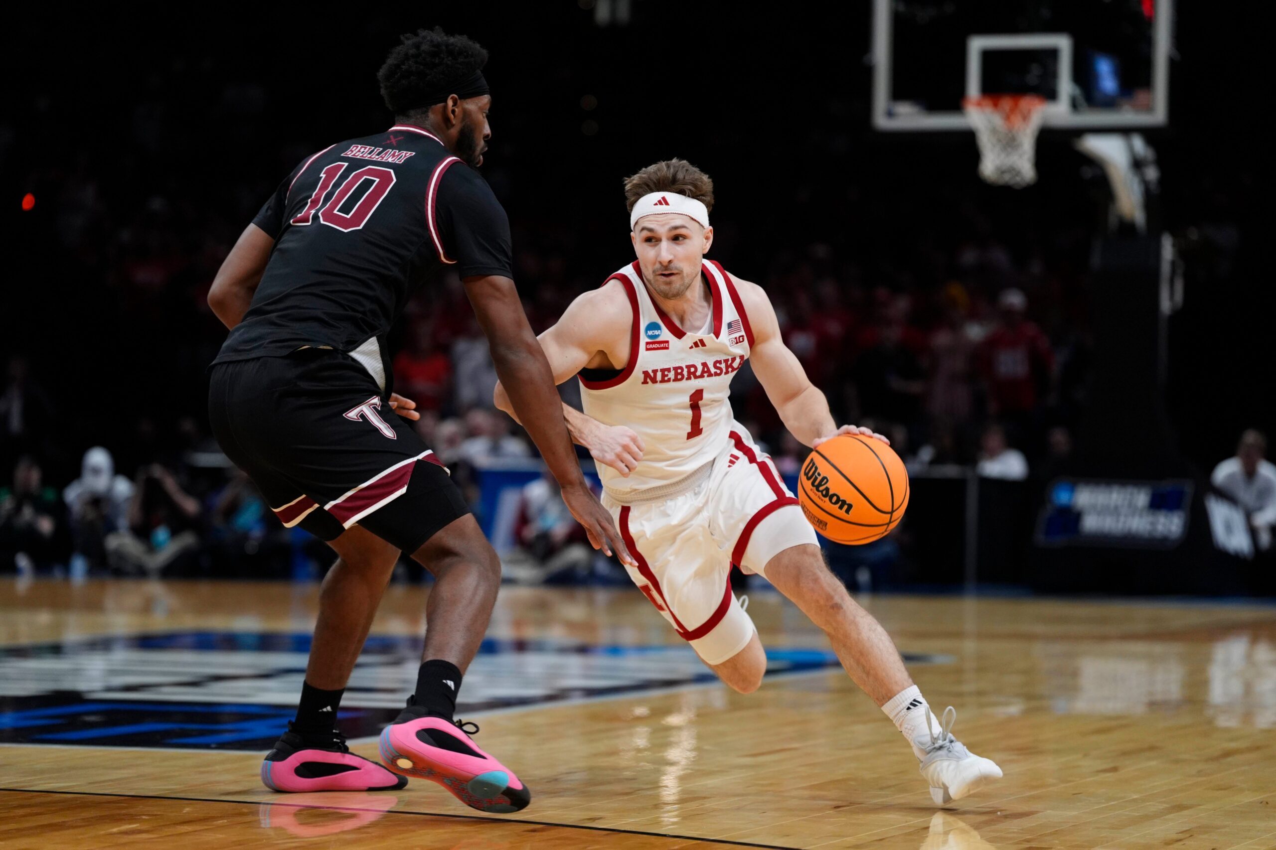 Nebraska Cornhuskers guard Sam Hoiberg (1) dribbles beside Troy Trojans forward Jerrell Bellamy (10) during a first-round game in the NCAA men's basketball tournament between Nebraska and Troy at Paycom Center in Oklahoma City, Thursday, March 19, 2026.
