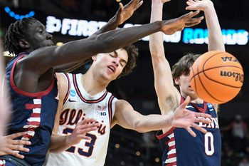 Penn Quakers forward Lucas-Allan Lueth (30) and Penn Quakers guard AJ Levine (0) defend Illinois Fighting Illini guard Keaton Wagler (23) Thursday, March 19, 2026, during the NCAA Men’s Basketball Tournament first round game at Bon Secours Wellness Arena in Greenville, South Carolina. Illinois Fighting Illini won 105-70.