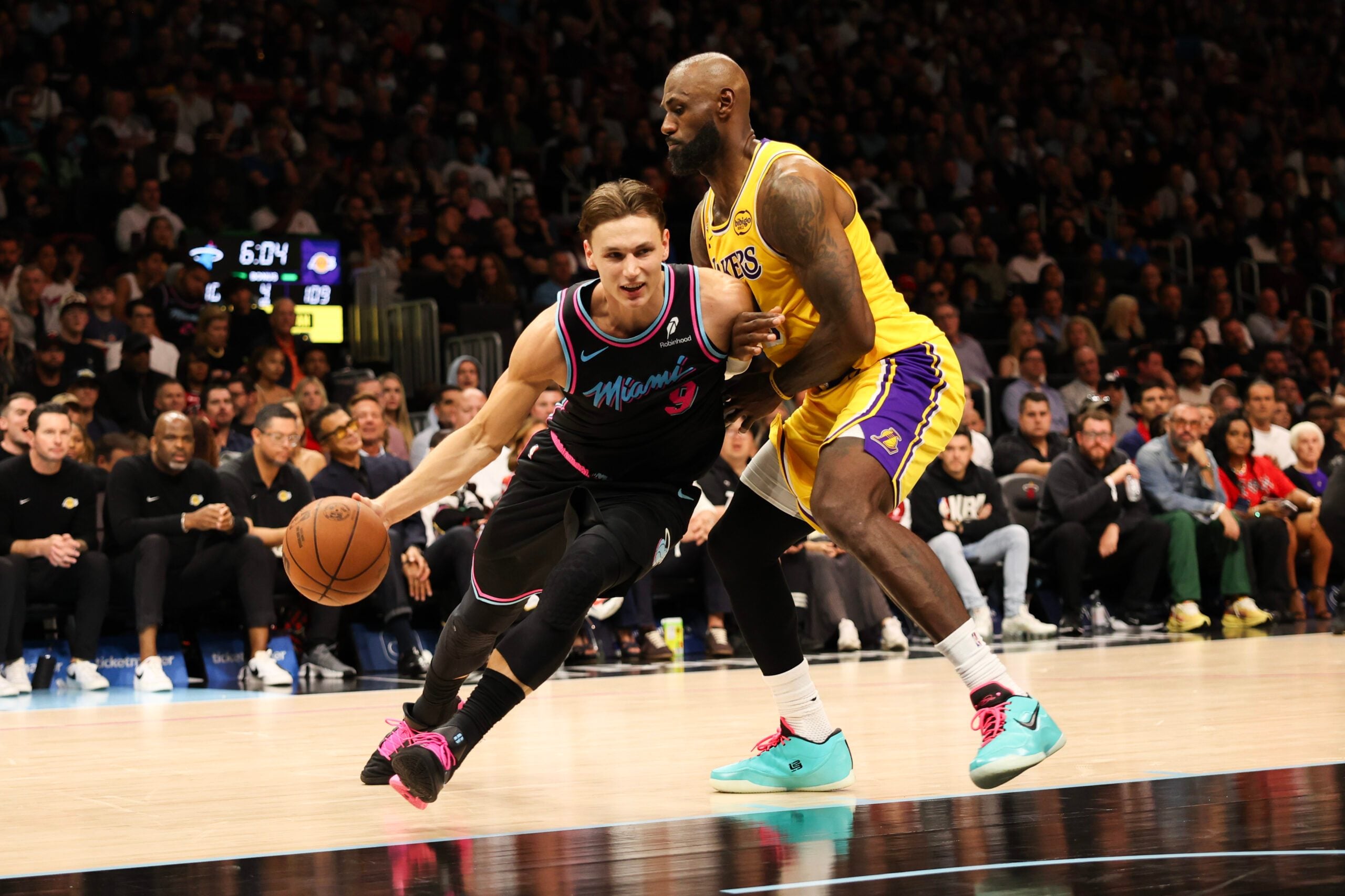 Mar 19, 2026; Miami, Florida, USA; Miami Heat guard Pelle Larsson (9) drives to basket against Los Angeles Lakers forward LeBron James (23) during second half at Kaseya Center. Mandatory Credit: Isabella Frias-Imagn Images