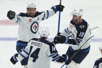 Mar 21, 2026; Pittsburgh, Pennsylvania, USA;  Winnipeg Jets defenseman Neal Pionk (4) celebrates after scoring a goal with right wing Gustav Nyquist (14) and center Jonathan Toews (19) against the Pittsburgh Penguins during the third period at PPG Paints Arena. Mandatory Credit: Charles LeClaire-Imagn Images