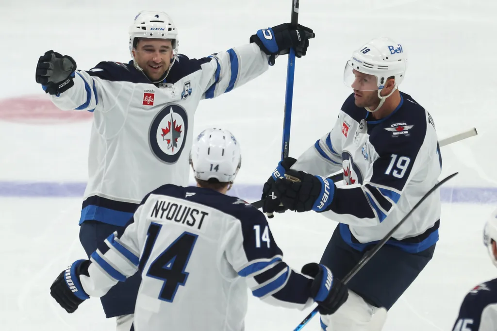 Mar 21, 2026; Pittsburgh, Pennsylvania, USA; Winnipeg Jets defenseman Neal Pionk (4) celebrates after scoring a goal with right wing Gustav Nyquist (14) and center Jonathan Toews (19) against the Pittsburgh Penguins during the third period at PPG Paints Arena. Mandatory Credit: Charles LeClaire-Imagn Images