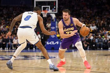 Mar 21, 2026; Orlando, Florida, USA; Los Angeles Lakers guard Luka Doncic (77) moves the ball past Orlando Magic forward Jamal Cain (8) in the second quarter at Kia Center. Mandatory Credit: Nathan Ray Seebeck-Imagn Images