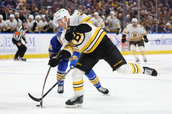 Mar 25, 2026; Buffalo, New York, USA;  Buffalo Sabres center Sam Carrick (10) tries to block a shot by Boston Bruins center Morgan Geekie (39) during the first period at KeyBank Center. Mandatory Credit: Timothy T. Ludwig-Imagn Images