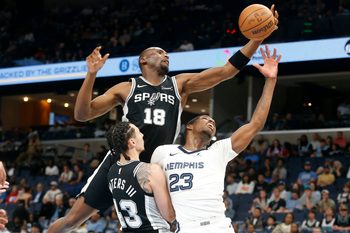 Mar 25, 2026; Memphis, Tennessee, USA; San Antonio Spurs center Bismack Biyombo (18) collects a rebound over forward Lindy Waters III (43) and Memphis Grizzlies forward Cedric Coward (23) during the fourth quarter at FedExForum. Mandatory Credit: Petre Thomas-Imagn Images