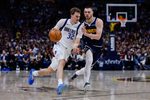 Mar 25, 2026; Denver, Colorado, USA; Dallas Mavericks forward Cooper Flagg (32) controls the ball as Denver Nuggets guard Christian Braun (0) guards in the third quarter at Ball Arena. Mandatory Credit: Isaiah J. Downing-Imagn Images