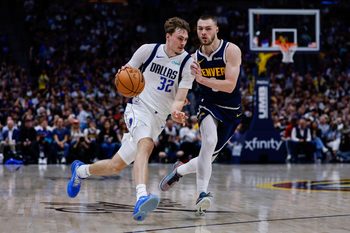 Mar 25, 2026; Denver, Colorado, USA; Dallas Mavericks forward Cooper Flagg (32) controls the ball as Denver Nuggets guard Christian Braun (0) guards in the third quarter at Ball Arena. Mandatory Credit: Isaiah J. Downing-Imagn Images