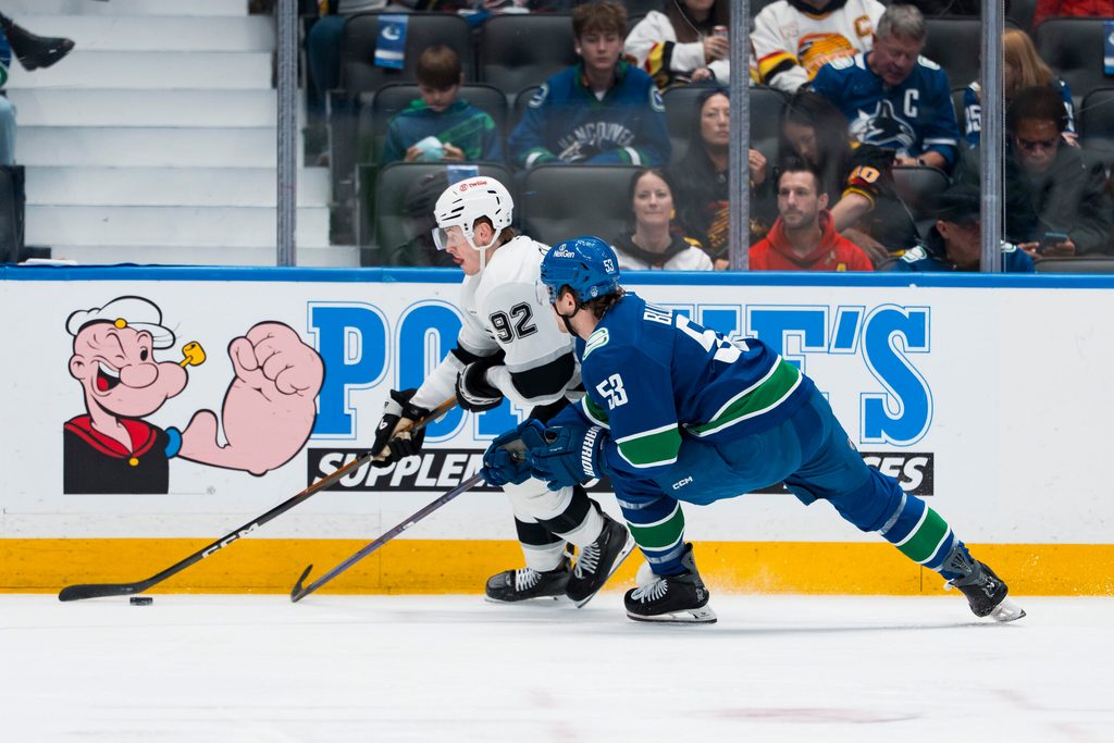 Mar 26, 2026; Vancouver, British Columbia, CAN; Los Angeles Kings defenseman Brandt Clarke (92) drives past Vancouver Canucks forward Teddy Blueger (53) in the first period at Rogers Arena. Mandatory Credit: Bob Frid-Imagn Images