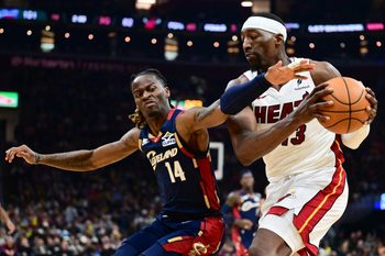 Mar 27, 2026; Cleveland, Ohio, USA; Cleveland Cavaliers guard Keon Ellis (14) goes for a loose ball against Miami Heat center Bam Adebayo (13) during the second half at Rocket Arena. Mandatory Credit: Ken Blaze-Imagn Images