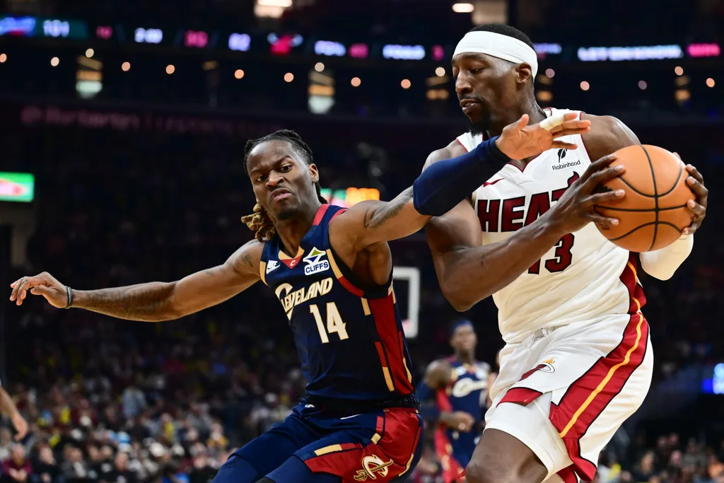 Mar 27, 2026; Cleveland, Ohio, USA; Cleveland Cavaliers guard Keon Ellis (14) goes for a loose ball against Miami Heat center Bam Adebayo (13) during the second half at Rocket Arena. Mandatory Credit: Ken Blaze-Imagn Images
