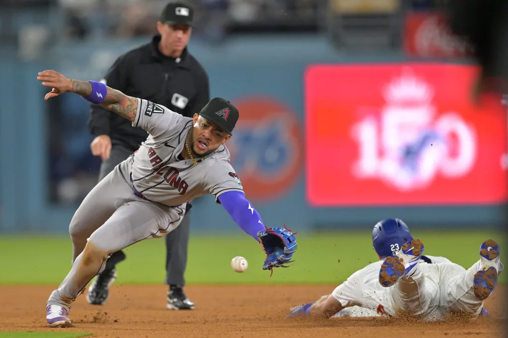Mar 27, 2026; Los Angeles, California, USA; Los Angeles Dodgers right fielder Kyle Tucker (23) is safe stealing second base against Arizona Diamondbacks shortstop Geraldo Perdomo (2) in the eighth inning at Dodger Stadium. Mandatory Credit: Jayne Kamin-Oncea-Imagn Images