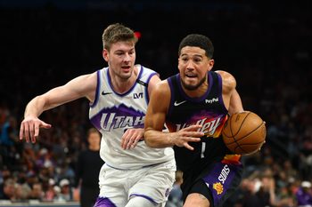 Mar 28, 2026; Phoenix, Arizona, USA; Phoenix Suns guard Devin Booker (1) moves the ball against Utah Jazz forward Kyle Filipowski (22) in the second half at Mortgage Matchup Center. Mandatory Credit: Mark J. Rebilas-Imagn Images