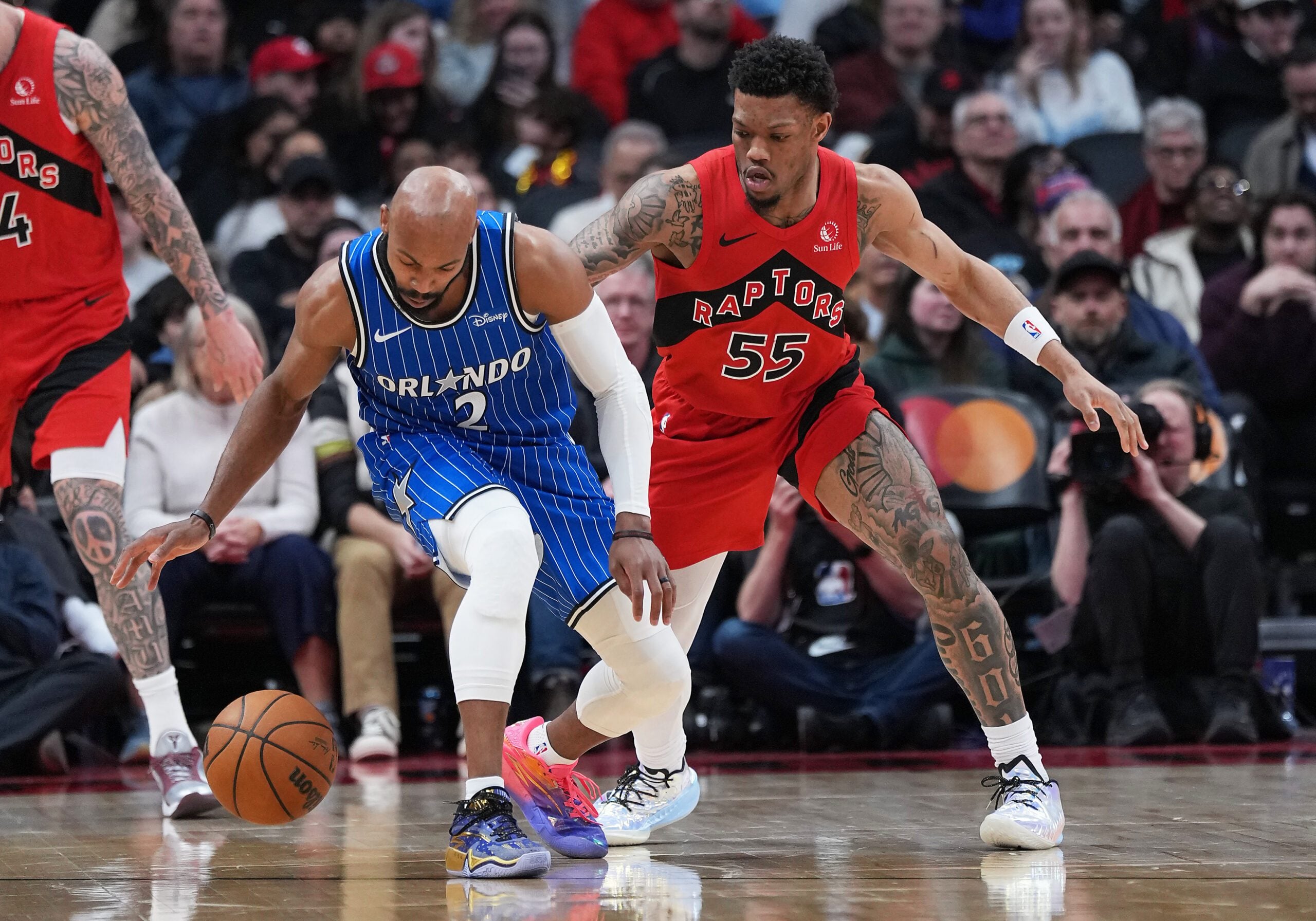 Mar 29, 2026; Toronto, Ontario, CAN; Orlando Magic guard Jevon Carter (2) controls the ball as Toronto Raptors guard Alijah Martin (55) tries to defend during the third quarter at Scotiabank Arena. Mandatory Credit: Nick Turchiaro-Imagn Images