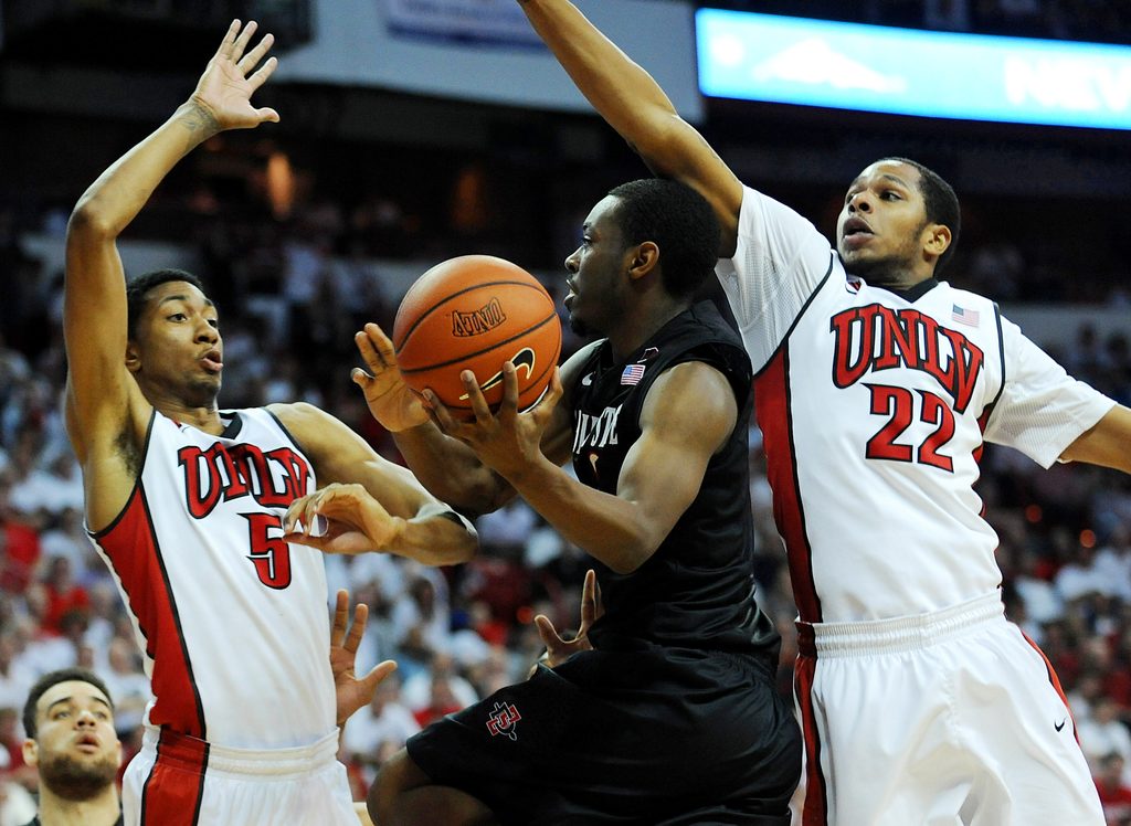 Mar 5, 2014; Las Vegas, NV, USA; San Diego State Aztecs guard Xavier Thames (2) attempts to shoot through the defense of UNLV Runnin' Rebels forward Christian Wood (5) and guard Jelan Kendrick (22) during an NCAA men's basketball game at Thomas and Mack Center. The Aztecs won the game 73-64. Mandatory Credit: Stephen R. Sylvanie-Imagn Images
