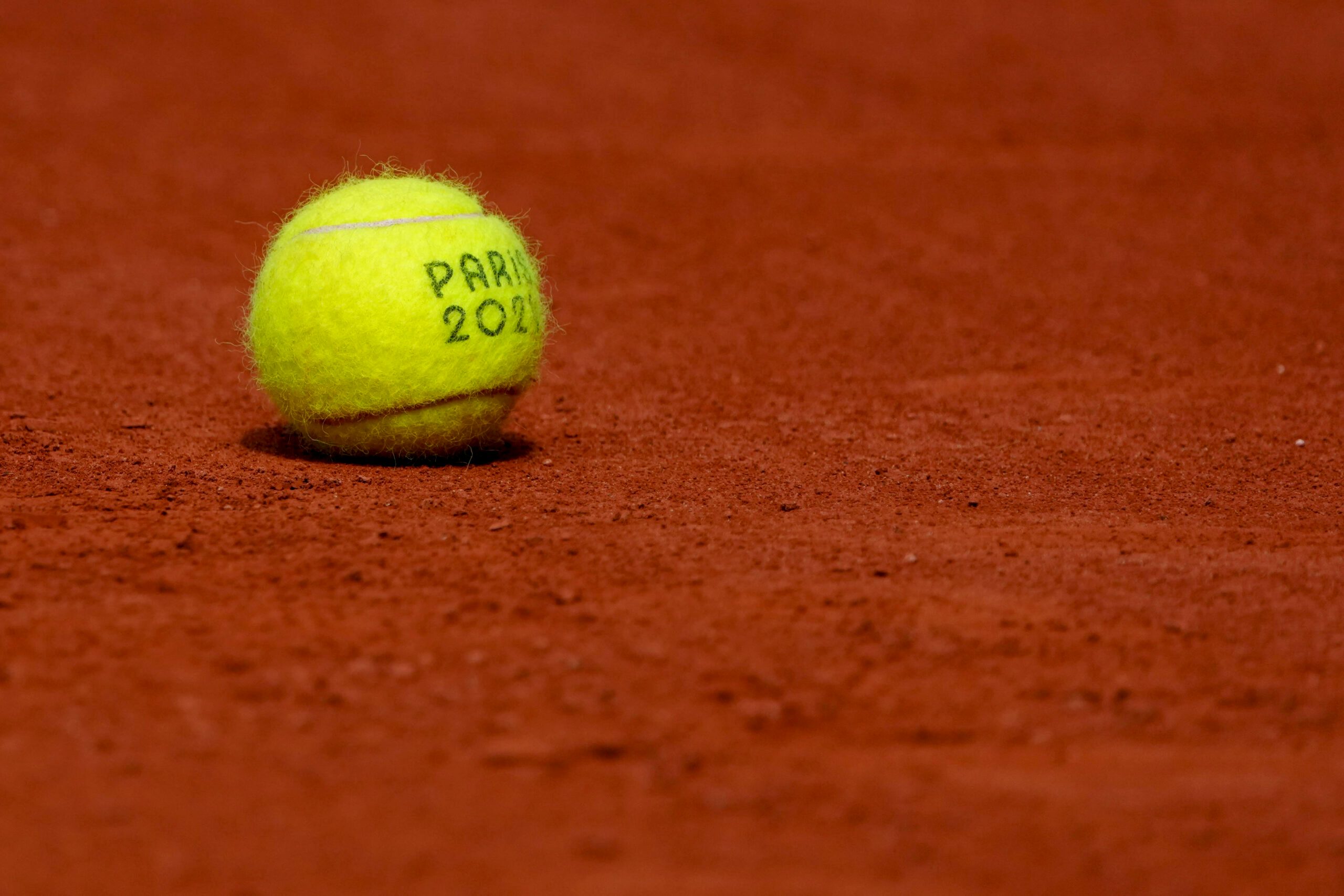 Jul 31, 2024; Paris, France; A tennis ball sits on the clay courts during the Paris 2024 Olympic Summer Games at Stade Roland Garros. Mandatory Credit: Kirby Lee-Imagn Images