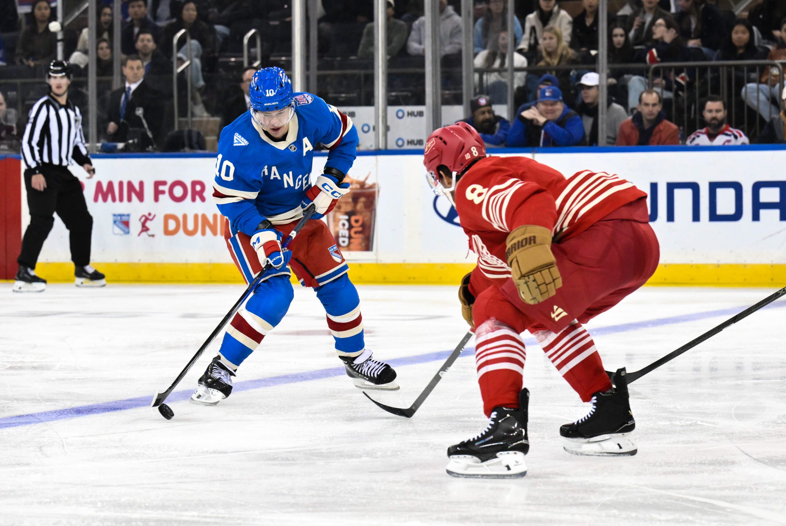 Nov 16, 2025; New York, New York, USA; New York Rangers left wing Artemi Panarin (10) skates with the puck while defended by Detroit Red Wings defenseman Ben Chiarot (8) during the third period at Madison Square Garden. Mandatory Credit: John Jones-Imagn Images
