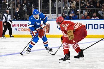 Nov 16, 2025; New York, New York, USA; New York Rangers left wing Artemi Panarin (10) skates with the puck while defended by Detroit Red Wings defenseman Ben Chiarot (8) during the third period at Madison Square Garden. Mandatory Credit: John Jones-Imagn Images