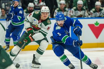 Dec 6, 2025; Vancouver, British Columbia, CAN; Vancouver Canucks left wing Conor Garland (8) gets past Minnesota Wild center Joel Eriksson Ek (14) in the third period at Rogers Arena. Mandatory Credit: Christopher Morris-Imagn Images