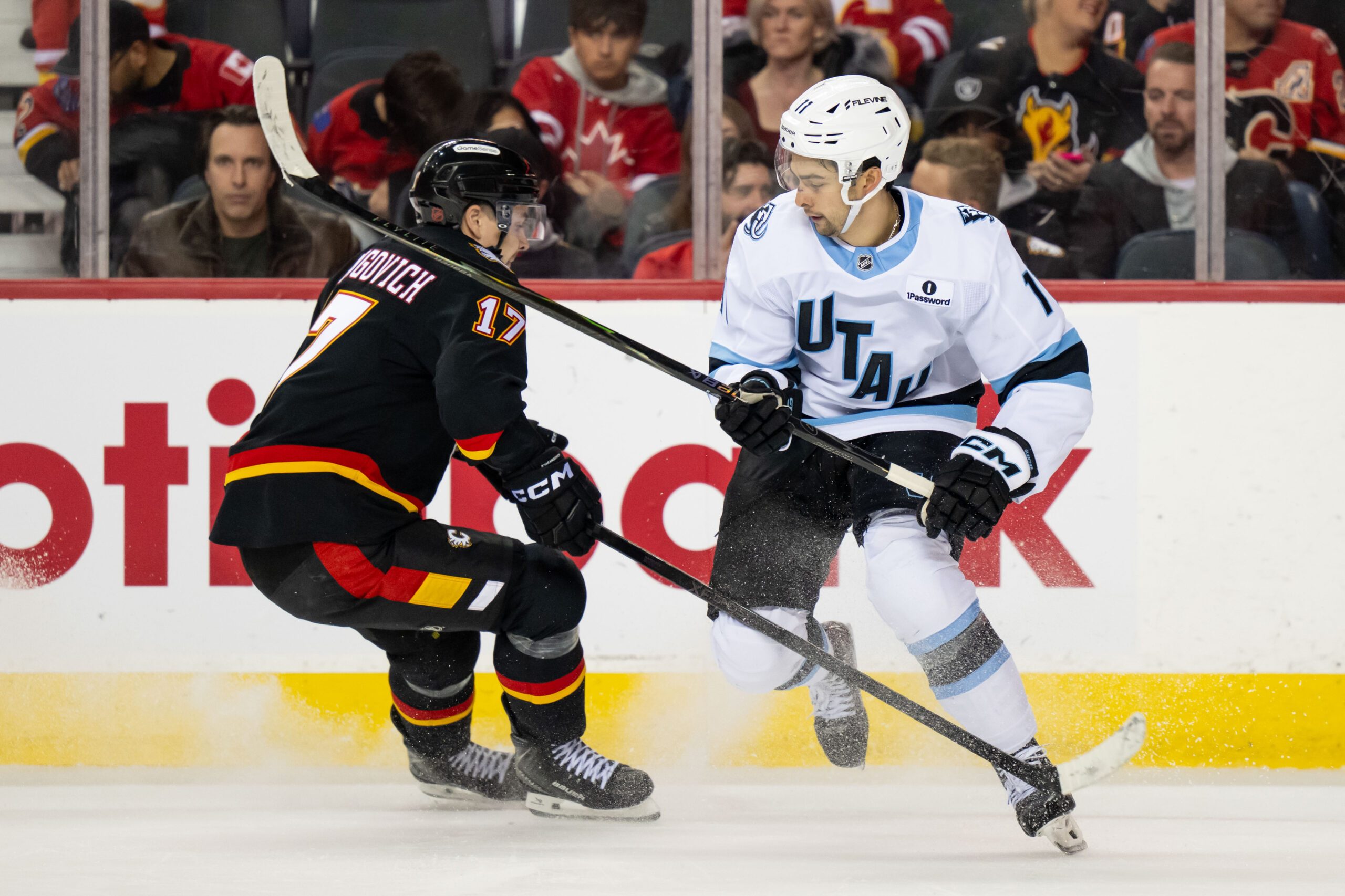 Dec 6, 2025; Calgary, Alberta, CAN; Utah Mammoth right wing Dylan Guenther (11) skates past Calgary Flames center Yegor Sharangovich (17) during the third period at Scotiabank Saddledome. Mandatory Credit: Brett Holmes-Imagn Images