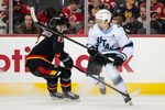 Dec 6, 2025; Calgary, Alberta, CAN; Utah Mammoth right wing Dylan Guenther (11) skates past Calgary Flames center Yegor Sharangovich (17) during the third period at Scotiabank Saddledome. Mandatory Credit: Brett Holmes-Imagn Images