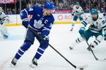 Dec 11, 2025; Toronto, Ontario, CAN; Toronto Maple Leafs forward Auston Matthews (34) controls the puck as San Jose Sharks defenseman Mario Ferraro (38) closes in during the third period at Scotiabank Arena. Mandatory Credit: John E. Sokolowski-Imagn Images