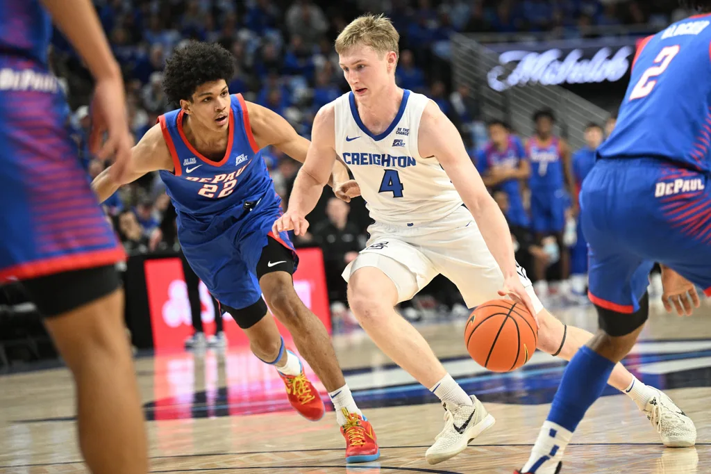 Feb 25, 2026; Omaha, Nebraska, USA; Creighton Bluejays guard Josh Dix (4) drives against DePaul Blue Demons guard Kruz McClure (22) during the second half at CHI Health Center Omaha. Mandatory Credit: Steven Branscombe-Imagn Images