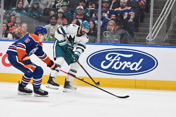 Mar 17, 2026; Edmonton, Alberta, CAN; Edmonton Oilers defenseman Connor Murphy (5) chases the puck with San Jose Sharks defenseman Nick Leddy (4) during the second period at Rogers Place. Mandatory Credit: Walter Tychnowicz-Imagn Images