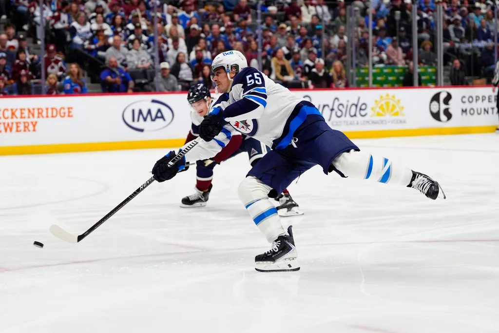 Mar 28, 2026; Denver, Colorado, USA; Winnipeg Jets center Mark Scheifele (55) shoots the puck in the first period against the Colorado Avalanche at Ball Arena. Mandatory Credit: Ron Chenoy-Imagn Images